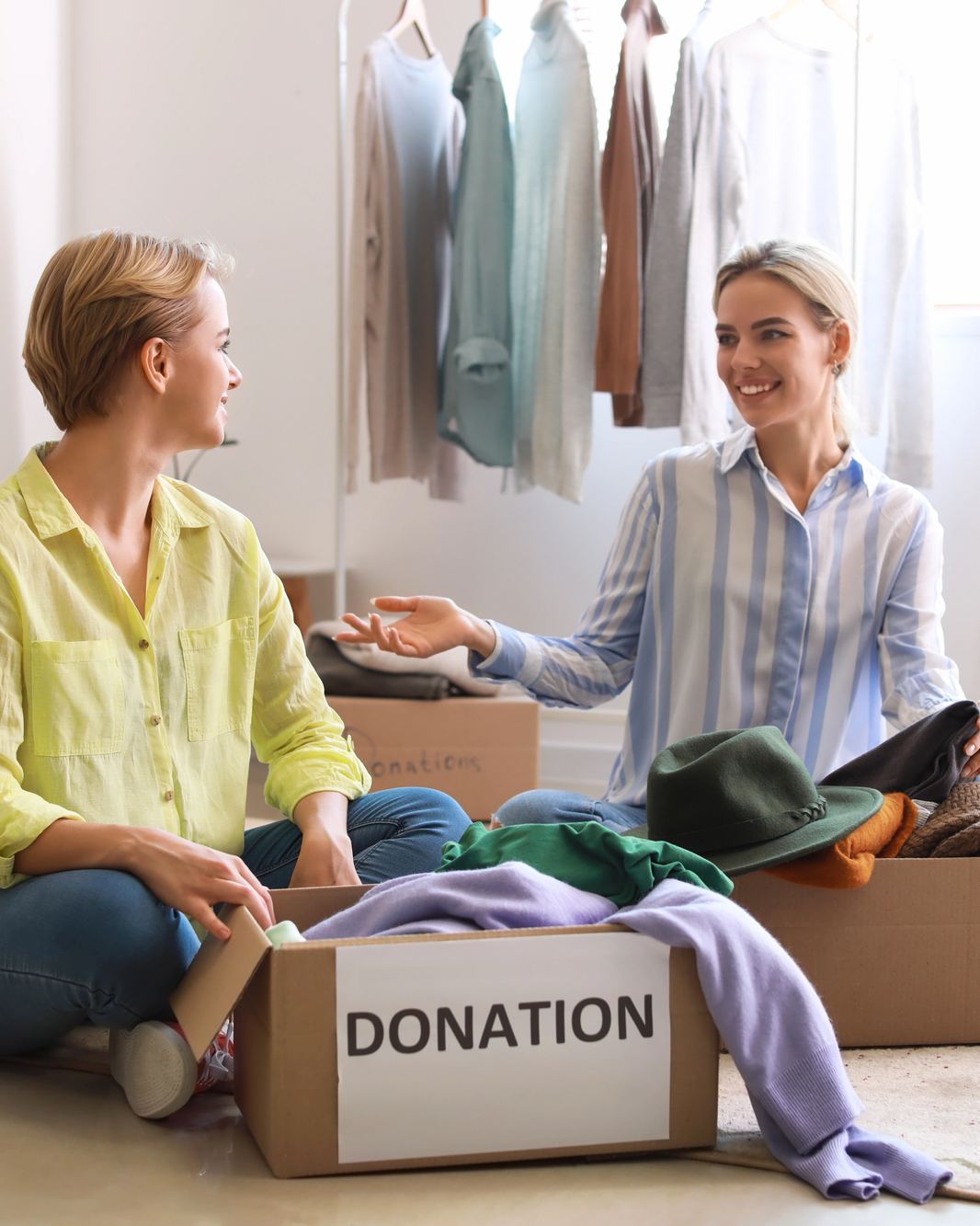 Two women sorting clothes into a donation box